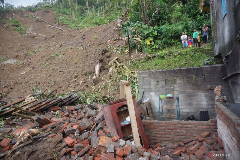 Warga melihat bangunan yang rusak diterjang longsor di Desa Sumurup, Trenggalek, Jawa Timur, Sabtu (22/10/2022). BPBD setempat mencatat, serangkaian bencana tanah bergerak dan longsor terjadi di 23 desa di delapan kecamatan yang menyebabkan sedikitnya 175