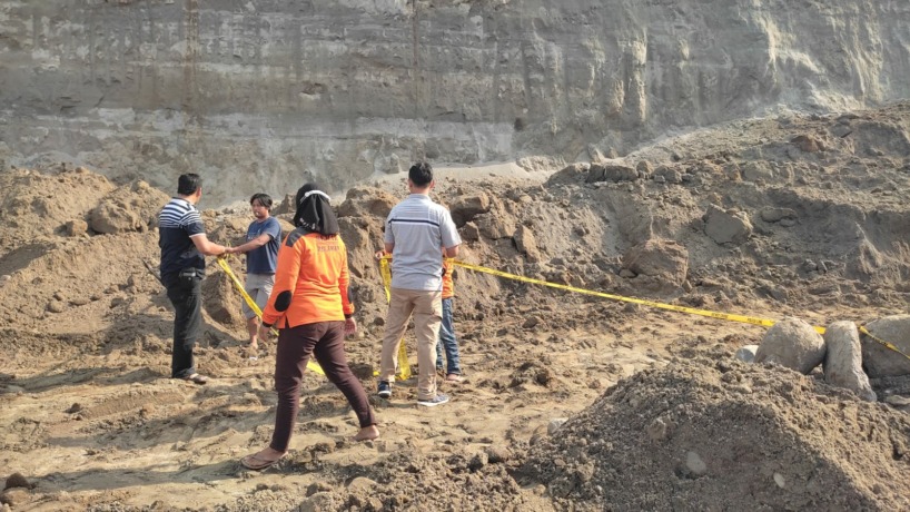 DISELIDIKI : Petugas kepolisian tengah memasang garis polisi di tambang galian C di Dusun Jaringansari, Desa Karangdiyeng, Kecamatan Kutorejo, Sabtu (22/10) siang. (Martda Vadetya/Jawa Pos Radar Mojokerto)