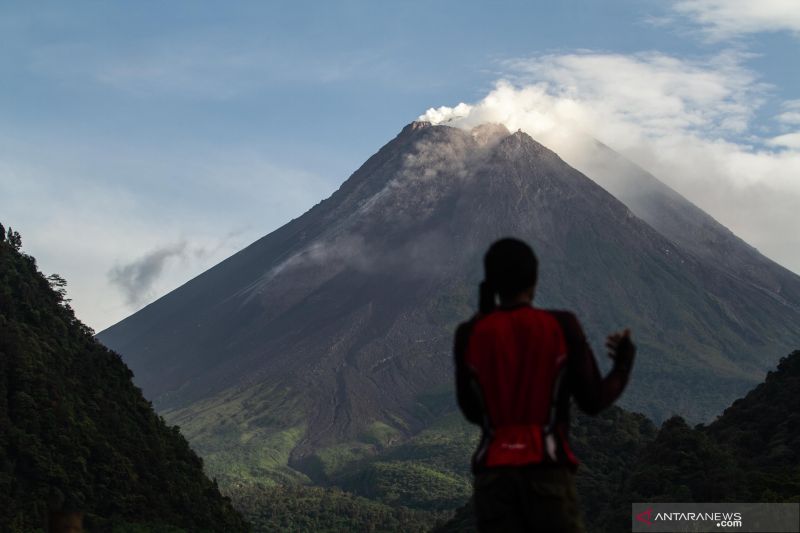 Warga menyaksikan kubah lava Gunung Merapi dari Kaliurang, Sleman, DI Yogyakarta, Minggu (9/1/2022). (ANTARA FOTO/Hendra Nurdiyansyah)