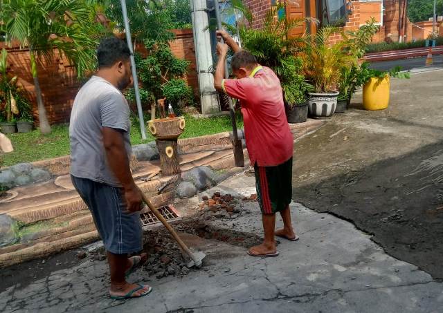 PERBAIKAN: Petugas membangun saluran air di halaman SMPN 1 Kota Mojokerto sebagai alternatif mengurangi genangan air saat musim hujan. (Indah Oceananda/Jawa Pos Radar Mojokerto)