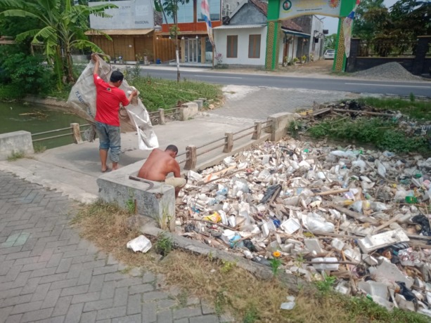 PRIHATIN: Warga membersihkan tumpukan sampah di Dam Menturus, Desa Ngareskidul, Kecamatan Gedeg. (Khudori Aliandu/Jawa Pos Radar Mojokerto)