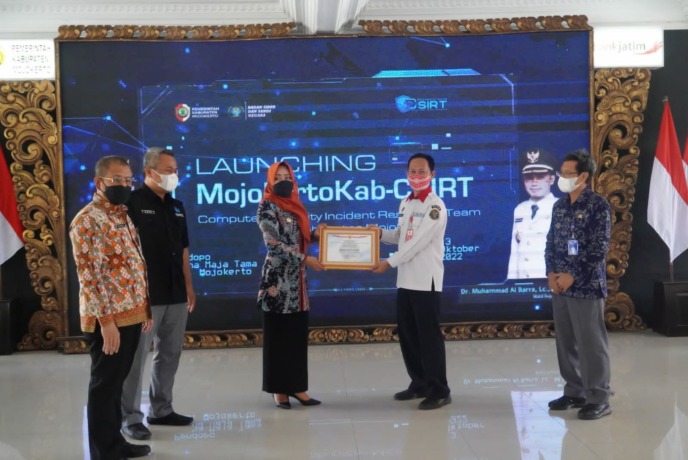 INOVASI: Bupati Ikfina Fahmawati memberi cinderamata kepada Direktur Keamanan Siber dan Sandi Teknologi Informasi dan Komunikasi, Media, dan Transportasi BSSN Rinaldy, didampingi Kepala Diskominfo Provinsi Jatim Hudiyono (kanan), Asisten 3 bidang administ