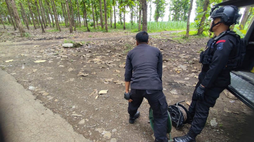 DILEDAKKAN: Tim Gegana Satbrimob Polda Jatim mengamankan lokasi pemusnahan tiga bom militer di Desa Pakis, Kecamatan Trowulan, Selasa (18/10).