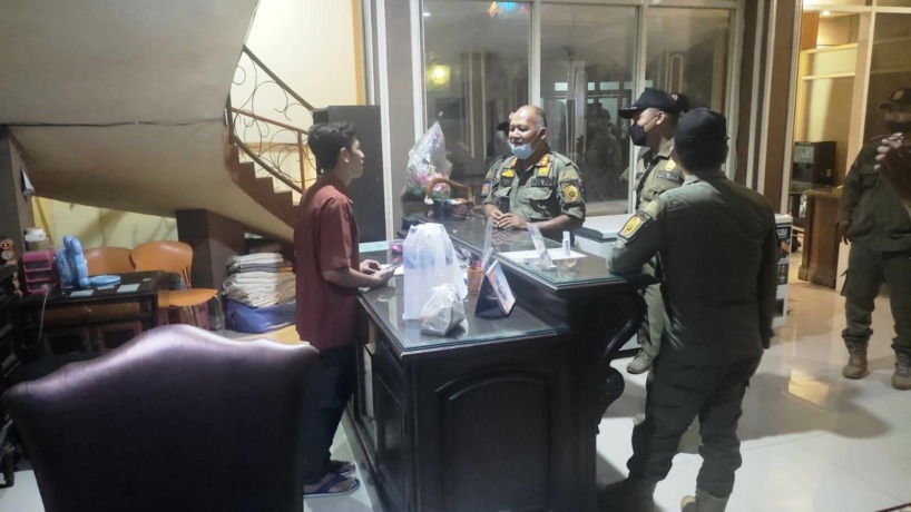 GIGIT JARI: Petugas Satpol PP Kabupaten Mojokerto tak bisa masuk ke salah satu homestay di Desa Banjaragung, Kecamatan Puri karena tak dilengkapi surat tugas. (Martda Vadetya/Jawa Pos Radar Mojokerto)