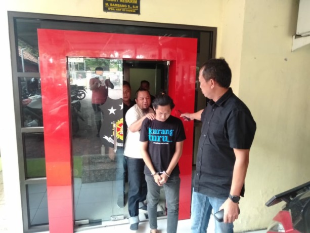 DIGELANDANG: Pelaku dikeler petugas ke Unit PPA Satreskrim Polres Mojokerto setelah diamankan di Polsek Pungging.