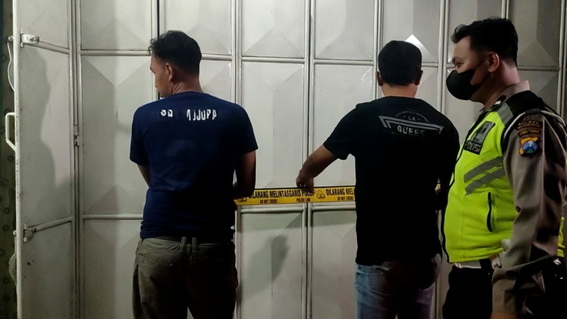 DISELIDIKI: Petugas Satreskrim Polres Mojokerto memasang garis polisi di Toko Bintang Jaya Gordyn Jalan Airlangga, Wonoayu, Mojosari, Kabupaten Mojokerto. Tempat kerja korban tersebut diduga lokasi eksekusi dilangsungkan oleh pelaku. (M Chariris/Jawa Pos