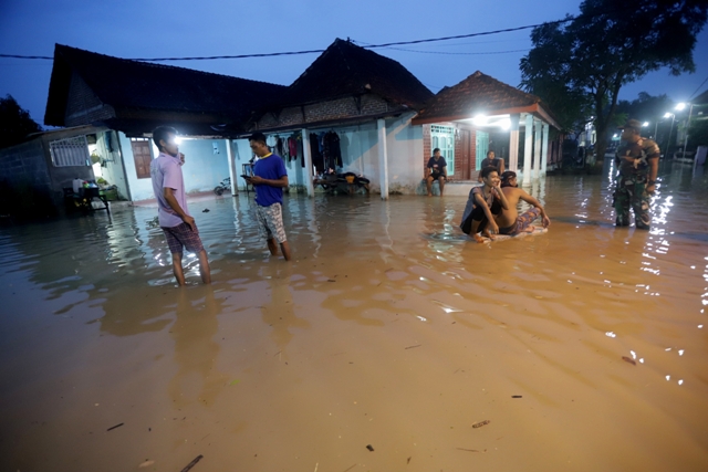 MELUAP LAGI: Warga Dusun Balong, Desa Banyulegi, Kecamatan Dawarblandong, Kabupaten Mojokerto, beraktivitas di tengah banjir, tadi malam. (Sofan Kurniawan/Jawa Pos Radar Mojokerto)
