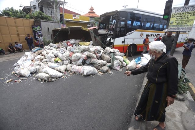 LAKA BUS: Seorang penumpang menunjukkan lokasi kecelakaan bus Harapan Jaya dengan truk pengangkut barang di Simpang Trowulan, Mojokerto, Rabu (30/11/2022). (Sofan Kurniawan/Jawa Pos Radar Mojokerto)