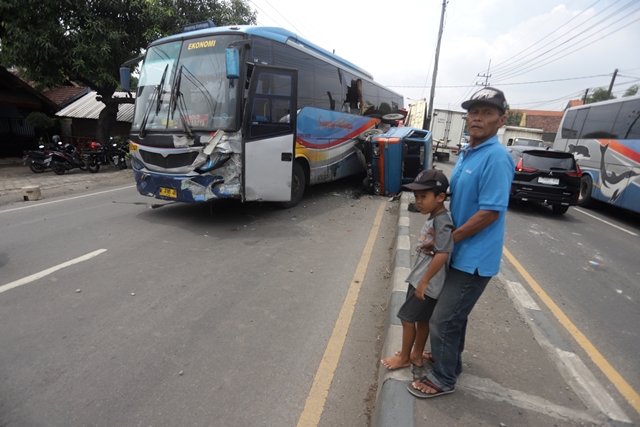 LAKA TROWULAN: Seorang penumpang selamat tampak menunggu bus operan usai kendaraan yang dikendarai terlibat kecelakaan di Trowulan, Mojokerto, Rabu (30/11) siang. (Sofan Kurniawan/Jawa Pos Radar Mojokerto)