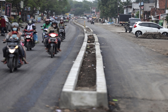 DIKEJAR DEADLINE: Proses pengaspalan dan median jalan pada proyek Peningkatan Jalan Empunala, Kota Mojokerto, Senin (14/11). (Sofan Kurniawan/Jawa Pos Radar Mojokerto)