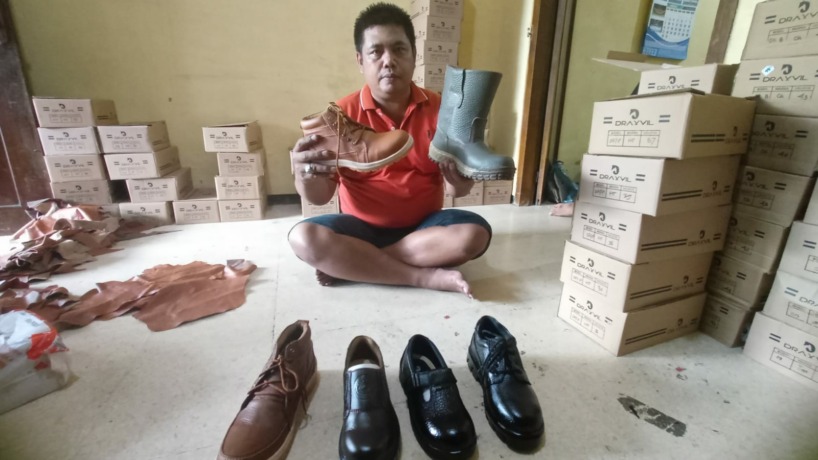 INOVASI: Abdul Latif memamerkan ragam jenis sepatu kulit buatannya yang sukses terjual ke seluruh Indonesia hingga menembus pasar luar negeri. (Indah Oceananda/Jawa Pos Radar Mojokerto)
