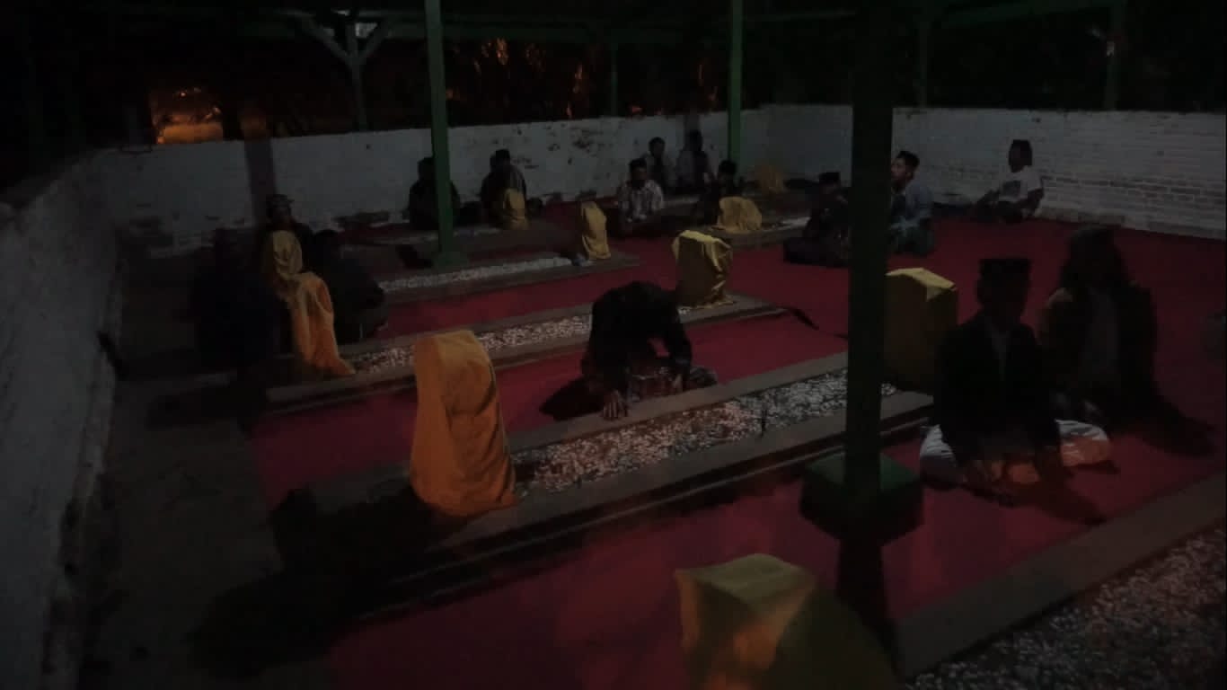 KHUSYUK: Peziarah berzikir di Makam Tujuh Troloyo yang berada di kompleks makam umum Desa Desa Sentonorejo, Kecamatan Trowulan, Kabupaten Mojokerto, Kamis (8/12) malam. (Mu