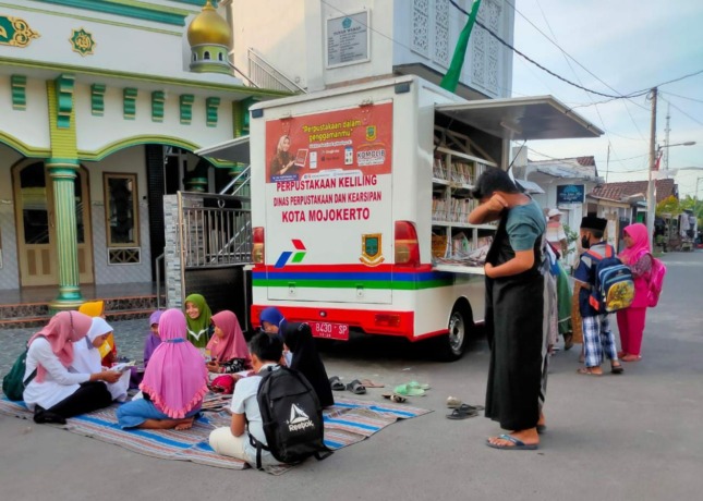ANTUSIAS: Perpustakaan Keliling Dispusip Kota Mojokerto menjadi jujukan anak-anak membaca buku.