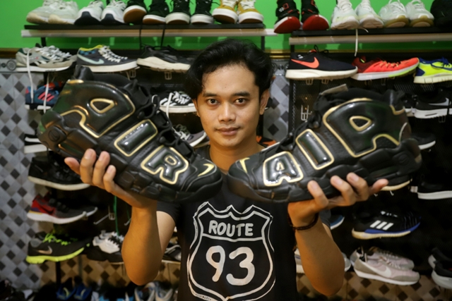 BIKIN GALAU: Defa Lusfandra menunjukkan sepatu thrift jenis Air Jordan yang ia jual. Sepatu thrift kian diminati seiring hype barang bekas branded menyerbu Indonesia. (Sofan Kurniawan/Jawa Pos Radar Mojokerto)