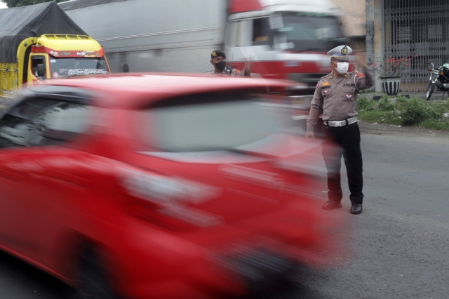 PADAT: Petugas kepolisian tengah mengatur lalu lintas di Simpang Lima Kenanten, Kecamatan Puri, Kabupaten Mojokerto, yang tengah padat. (Sofan Kurniawan/Jawa Pos Radar Mojokerto)