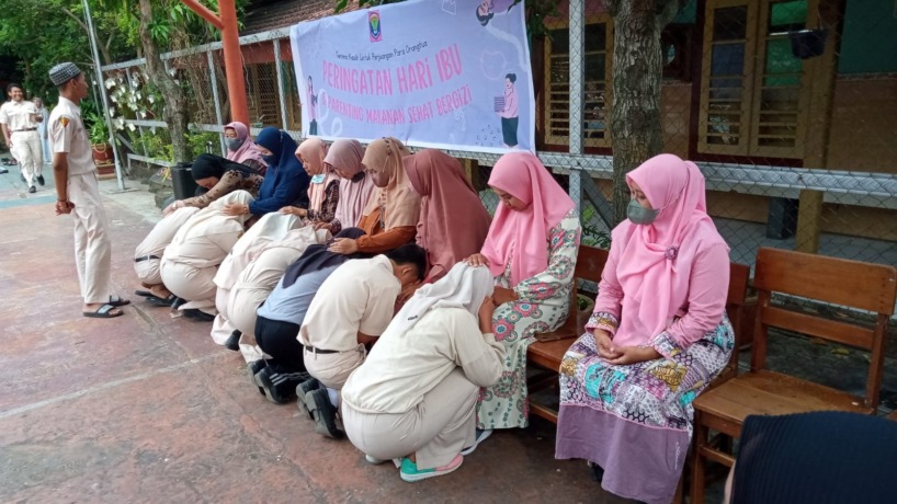BERSIMPUH: Siswa SMPN 7 Kota Mojokerto saat melakukan sungkem kepada orang tuanya saat peringatan Hari Ibu, Kamis (22/12). (Rizal Amrulloh/Jawa Pos Radar Mojokerto)