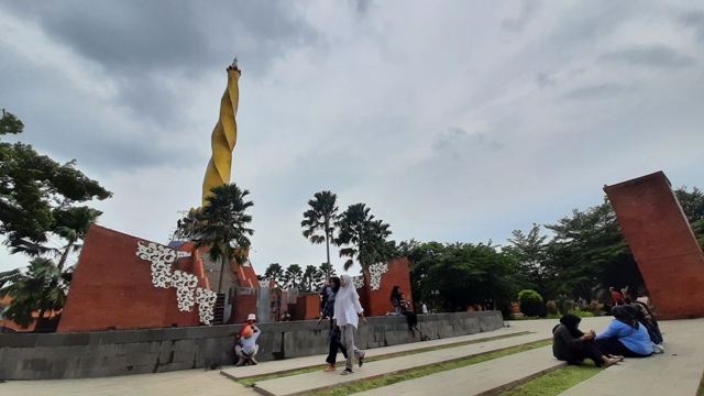 RAMAI: Sejumlah wisatawan saat berkunjung di kawasan Alun-Alun Kota Mojokerto dengan latar tugu baru yang baru rampung dikerjakan akhir tahun ini, Selasa (27/12). (Rizal Amrulloh/Jawa Pos Radar Mojokerto)