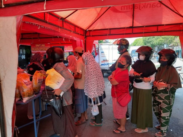 DIBURU: Warga mengantre untuk membeli bahan pokok dalam kegiatan operasi pasar di Pasar Tanjung Anyar, Kota Mojokerto, kemarin. (Rizal Amrulloh/Jawa Pos Radar Mojokerto)