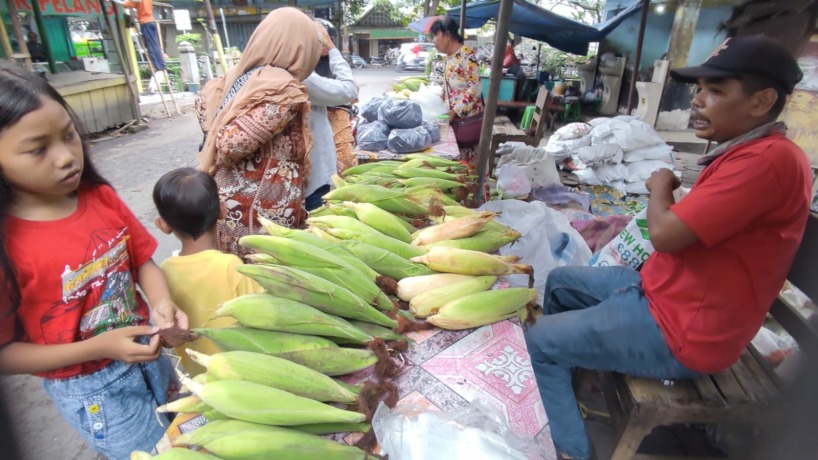 LARIS MANIS: Lukman tengah melayani pembeli yang silih berganti ke lapaknya di Pasar Raya Mojosari, kemarin. (Martda Vadetya/Jawa Pos Radar Mojokerto)