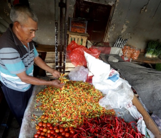 CUACA: Pedagang menata cabai berbagai jenis di lapak daganganya di Pasar Tajung Anyar Kota Mojokerto, kemarin. Cuaca buruk menyebabkan kualitas hasil pertanian menurun. Hal itu berdampak pada kenaikan harga kebutuhan pokok di pasar, seperti cabai rawit ya
