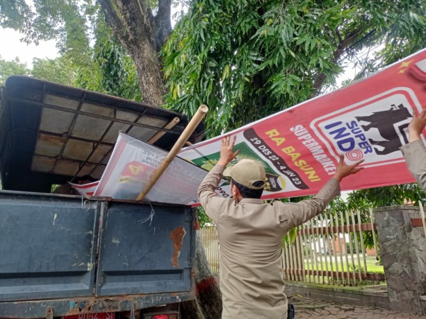 DISITA: Petugas Satpol PP Kota Mojokerto menyita reklame banner baliho milik Superindo RA Basuni yang mencelakai pengguna jalan Mojopahit, Senin (2/1). (Yulianto Adi Nugroho/Jawa Pos Radar Mojokerto)
