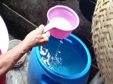 TAK JERNIH: Sunarti menunjukkan kondisi air PDAM di rumahnya yang keruh beberapa hari terakhir.
