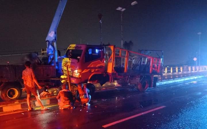 TERSANGKUT: Kondisi truk yang menabrak median Jembatan Mertex di di Jalan Raya Bypass, Desa Lengkong, Kecamatan Mojoanyar, Kabupaten Mojokerto, Sabtu (28/1). (Yulianto Adi Nugroho/JPRM)