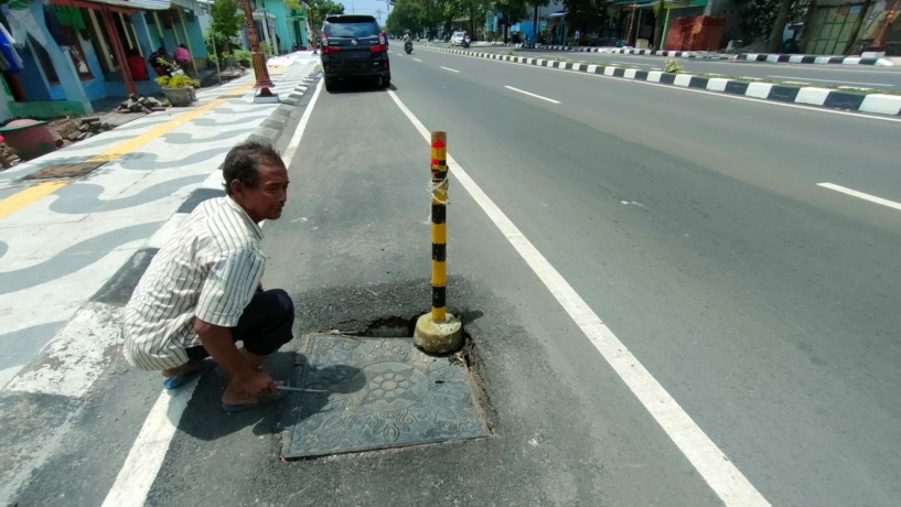JEBOL: Baja penutup saluran drainase yang berada di badan Jalan Empunala, Kecamatan Magersari, Kota Mojokerto retak akibat tak kuat menahan berat kendaraan yang melintas, kemarin (29/1). (Sofan Kurniawan/JPRM)
