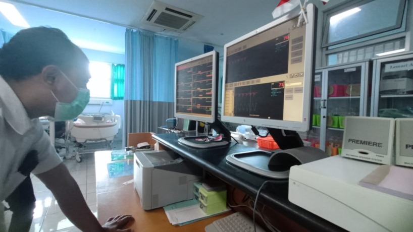 PANTAU: Salah satu perawat RSUD dr Wahidin Sudiro Husodo Kota Mojokerto mengecek kondisi salah satu pasien yang menjalani perawatan di ruang rawat inap infeksius melalui monitor.  (Indah Oceananda/Jawa Pos Radar Mojokerto)