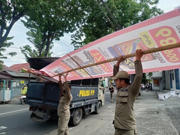 DISITA: Petugas Satpol PP Kota Mojokerto mengangkut baliho milik Suprindo RA Basuni yang terpasang di sepanjang Jalan Majapahit, kemarin. (Yulianto Adi Nugroho/Jawa Pos Radar Mojokerto)