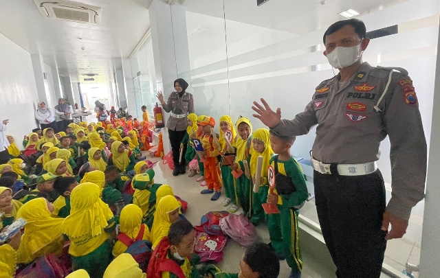 RIANG: Petugas Satlantas Polres Mojokerto Kota mengenalkan rambu kepada rombongan TK dan PAUD di kantor Satpas Polres Mojokerto Kota, kemarin.