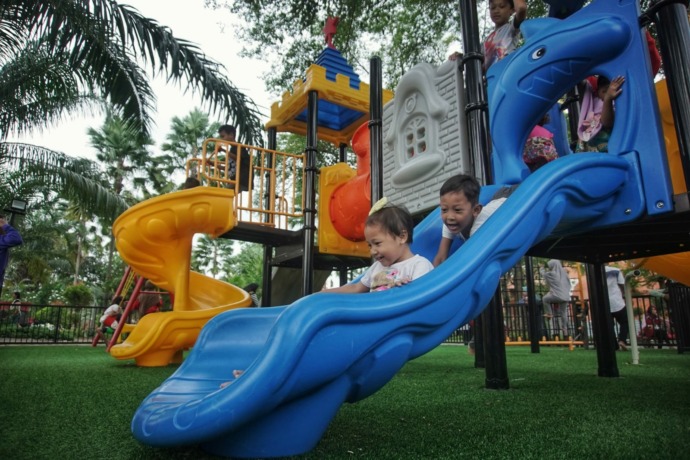 ASYIK: Pengunjung anak-anak sedang menikmati fasilitas playground di Alun-Alun Kota Mojokerto. (Rizal Amrulloh/Jawa Pos Radar Mojokerto)