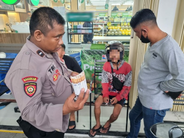 DIAMANKAN: Petugas Satsabhara Polres Mojokerto Kota mengamankan penjual rokok ilegal. (Yulianto Adi Nugroho/Jawa Pos Radar Mojokerto)