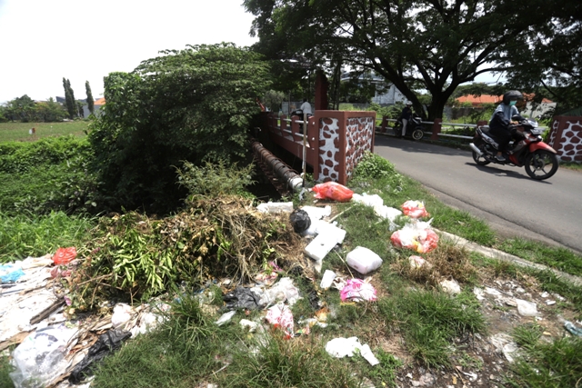 BERSERAKAN: Sampah rumah tangga yang dibuang sembarangan berceceran di sisi kiri jembatan Lingkungan Kuwung, Kelurahan Meri, Kecamatan Kranggan. (Sofan Kurniawan/JPRM)