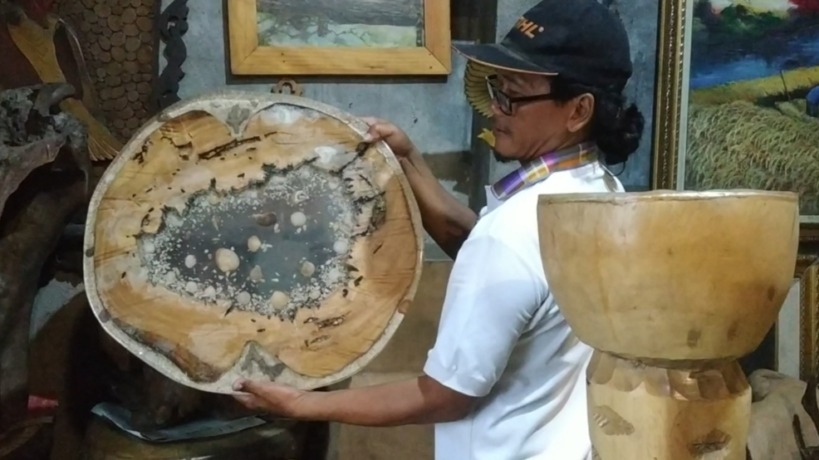 TEKUN: Agus Suyono menunjukkan lukisan tokoh berbahan kayu bekas di galerinya. (Farisma Romawan/JPRM)