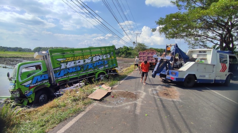 DIDEREK: Truk bernopol S 9157 NI yang nyungsep ke sawah dievakuasi mobil derek usai terlibat kecelakaan maut di Jalan Raya Desa Segunung, Kecamatan Dlanggu, Sabtu (14/1) siang. (Martda Vadetya/Jawa Pos Radar Mojokerto)