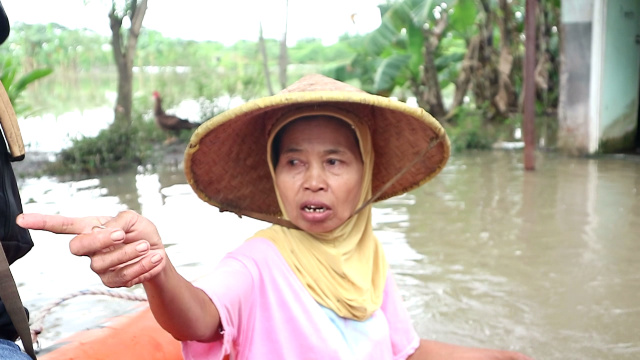 JENGUK SAUDARA: Solatin, kerabat korban terdampak banjir, datangi rumah kerabatnya menggunakan perahu karet untuk mengirimkan obat kepada korban terdampak banjir yang sakit, Jumat (10/2). (Diki for JPRM)