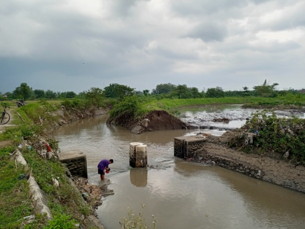 SEGERA DITANGANI: Warga beraktivitas di sekitar tanggul Sungai Sumberkembar, Dusun Tambak Agung, Desa Kebondalem, Kecamatan Mojosari, Kabupaten Mojokerto, yang mengalami ambrol, kemarin. (Yulianto Adi Nugroho/JPRM)