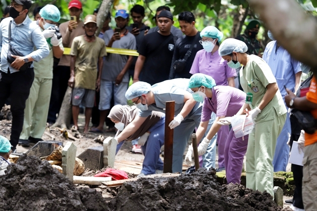 DIUSUT: Proses pembongkaran makam korban di pemakaman umum Dusun Pudakpolo, Desa Puloniti, Kecamatan Bangsal, Kabupaten Mojokerto, Selasa (7/2) siang. (Sofan Kurniawan/JPRM)