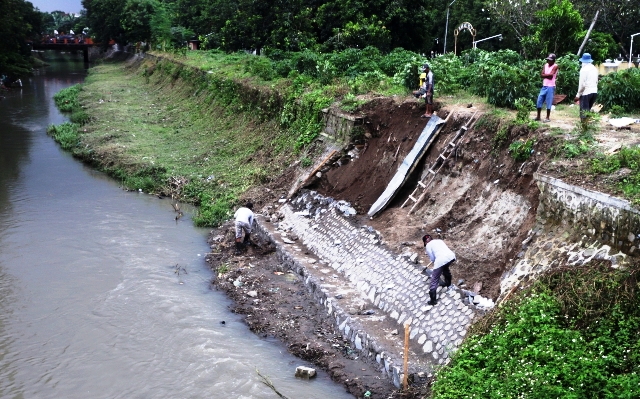 DIPERBAIKI: Sejumlah pekerja tengah melakukan perbaikan tanggul Sungai Sadar yang longsor akibat erosi di Kecamatan Kranggan, Jumat (10/2) kemarin. (Sofan Kurniawan/JPRM)