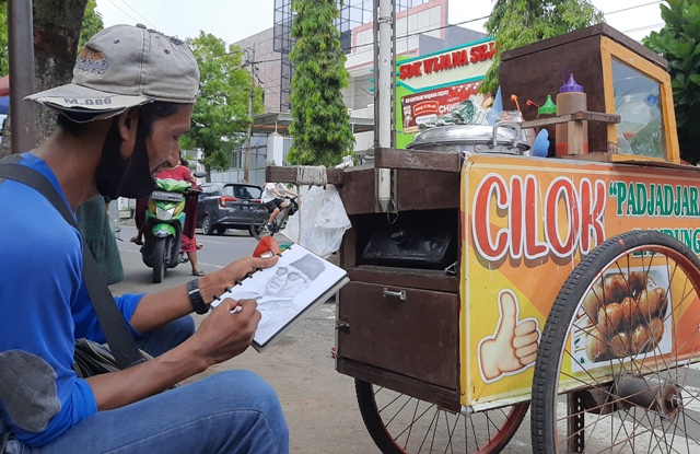KREATIF: Dahlan Muchlis saat membuat karya sketsa saat menunggu pelanggannya di Jalan Pemuda, Kota Mojokerto, Kamis (2/2). (Rizal Amrulloh/JPRM)