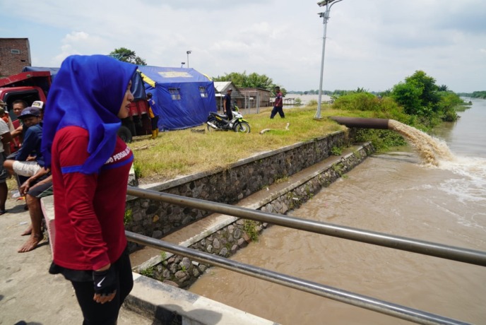 DITINDAKLANJUTI: Bupati Ikfina Fahmawati saat meninjau lokasi terdampak banjir di Dusun Gembongan, Desa Jotangan, Kecamatan Mojosari, Jumat (10/2). (RIzal Amrulloh/JPRM)