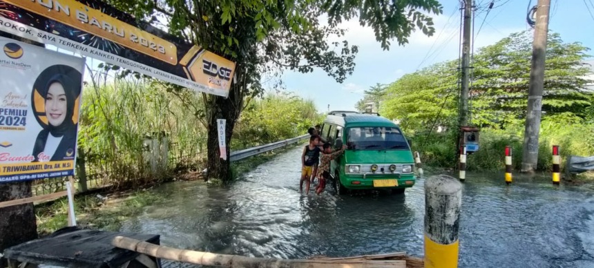 DAMPAK BANJIR: Banjir yang meluber hingga jalan raya di Perumdam, Kelurahan Blooto, Kecamatan Prajurit Kulon juga akibatkan kendaraan mogok, Rabu (22/3). (Khudori Aliandu/JPRM)