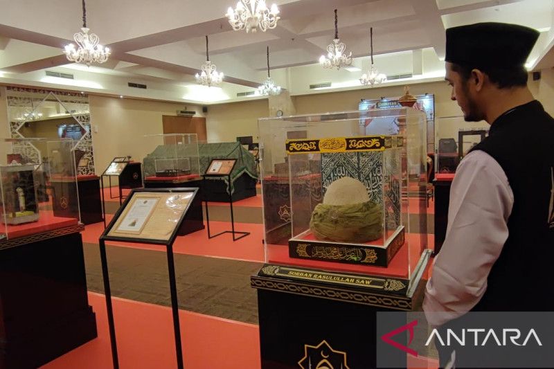 Salah satu petugas penjaga artefak Rasulullah tengah melihat sorban yang biasa dikenakan oleh Nabi Muhammad SAW saat Pameran Artefak Rasulullah di Masjid At-Tin, TMII, Jakarta Timur, Rabu (29/3/2023). ANTARA/Syaiful Hakim