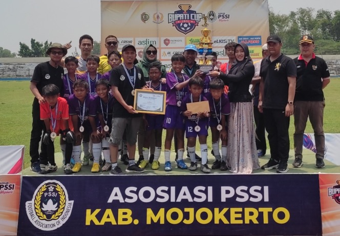 KAMPIUN: Bupati Ikfina Fahmawati bersama Ketua Askab PSSI Mojokerto KH Fathur Rohman menyerahkan piala juara I Bupati Cup 2023 U-12 pada SSB Mojosari FC.