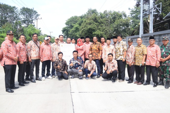 WUJUD PEMBANGUNAN: Bupati Ikfina Fahmawati menyerahkan SPPT PBB-P2 di Jalan Raya Lebaksono, Kecamatan Pungging yang dibangun dari APBD 2022 yang salah satunya bersumber dari PBB.