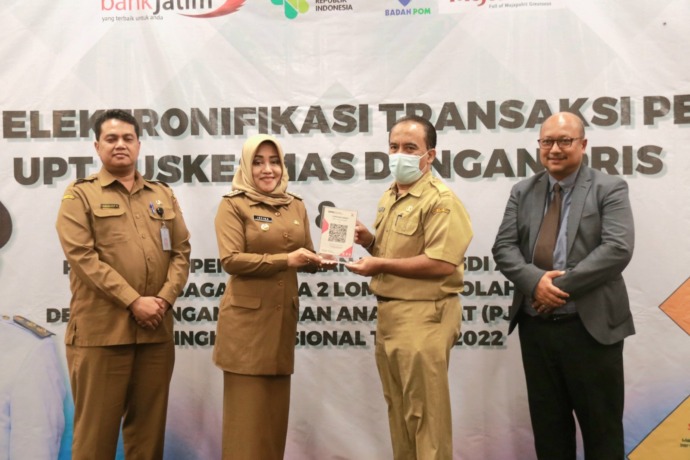 CASHLESS: Bupati Ikfina Fahmawati didampingi Kepala Dinkes Kabupaten Mojokerto dr Ulum Rokhmat Rokhmawan saat menyerahkan barcode QRIS untuk digitalisasi transaksi kepada Kepala UPT Puskesmas Sooko dr Dadang Hendryanto.