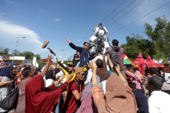TRADISI: Warga berebut menangkap sepatu dari gunungan yang diarak keliling kampung di depan Balai Desa Medali, Kecamatan Puri, Kabupaten Mojokerto, kemarin. (Sofan Kurniawan/JPRM)