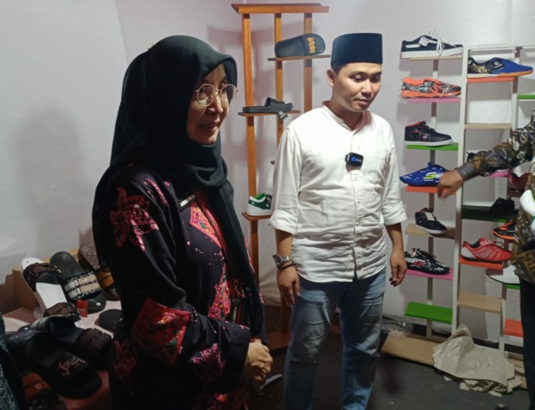 PRODUK LOKAL: Kepala Dinas Koperasi, Usaha Kecil dan Menengah Provinsi Jatim Andromeda Qomariah dan Wakil Bupati Mojokerto Muhammad Al Barraa di stan alas kaki saat Bazar UMKM di Desa Medali, Kecamatan Puri, tadi malam. (Yulianto Adi Nugroho/JPRM)