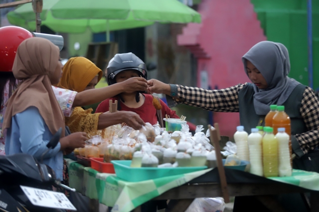 DADAKAN: Seorang pedagang melayani pembeli di Jalan Raya Kedungmaling, Kecamatan Sooko, kemarin. (Sofan Kurniawan/JPRM)